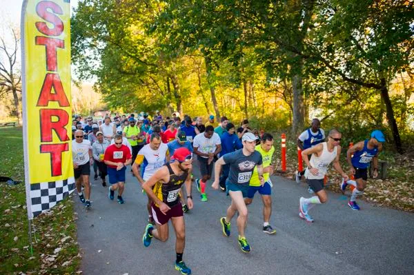 Runners starting a race, with a large yellow "START" banner on the left.