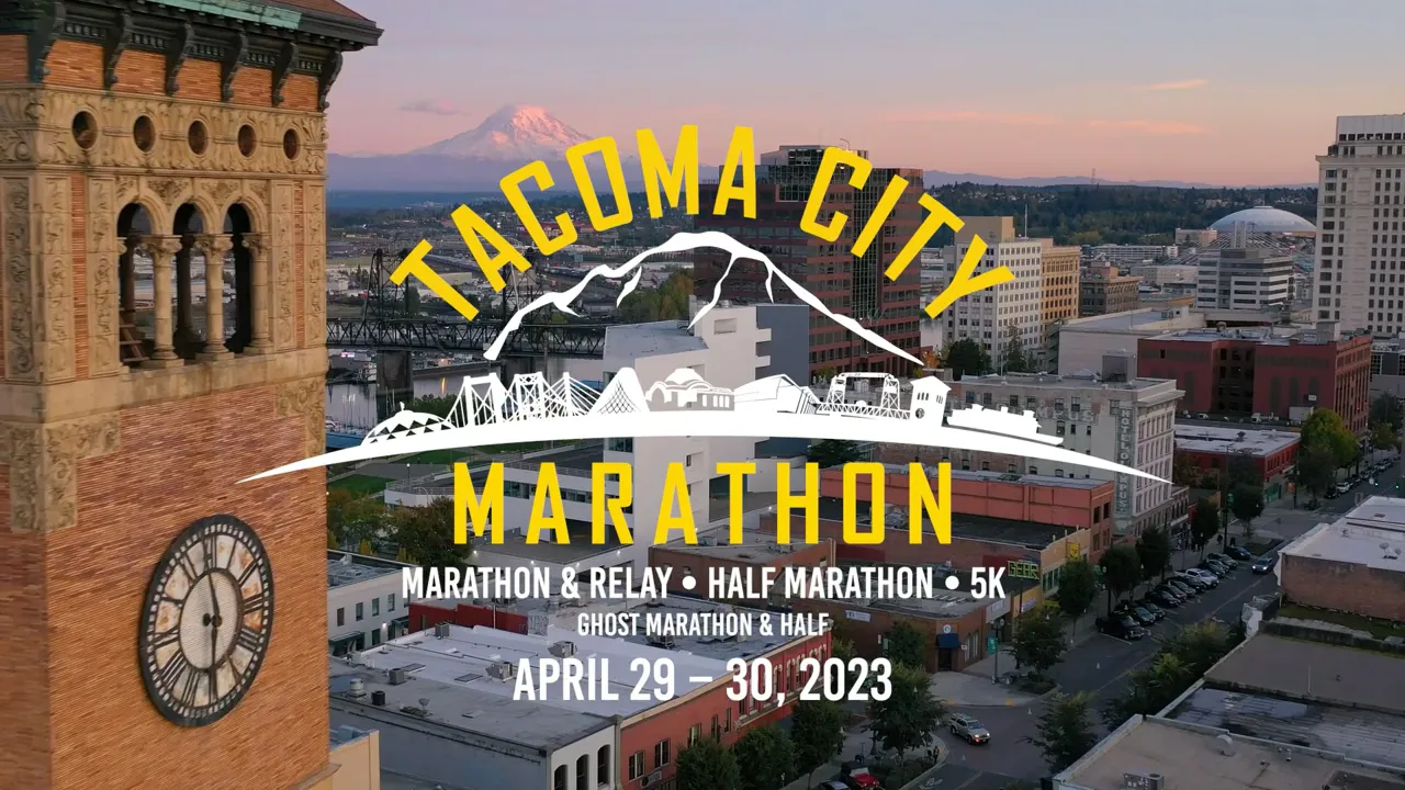 Aerial view of Tacoma City with Mount Rainier in the background, featuring the Tacoma City Marathon branding and event details.