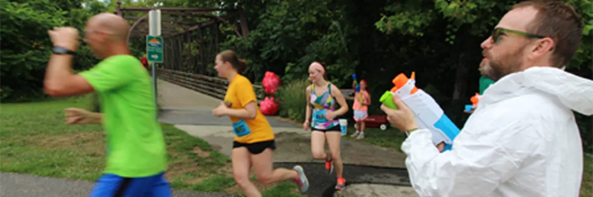 Runners participating in a race, with some holding water guns, suggesting a fun and interactive event.