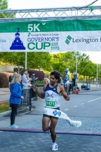 Runner crossing the finish line at the Governor's Cup race.