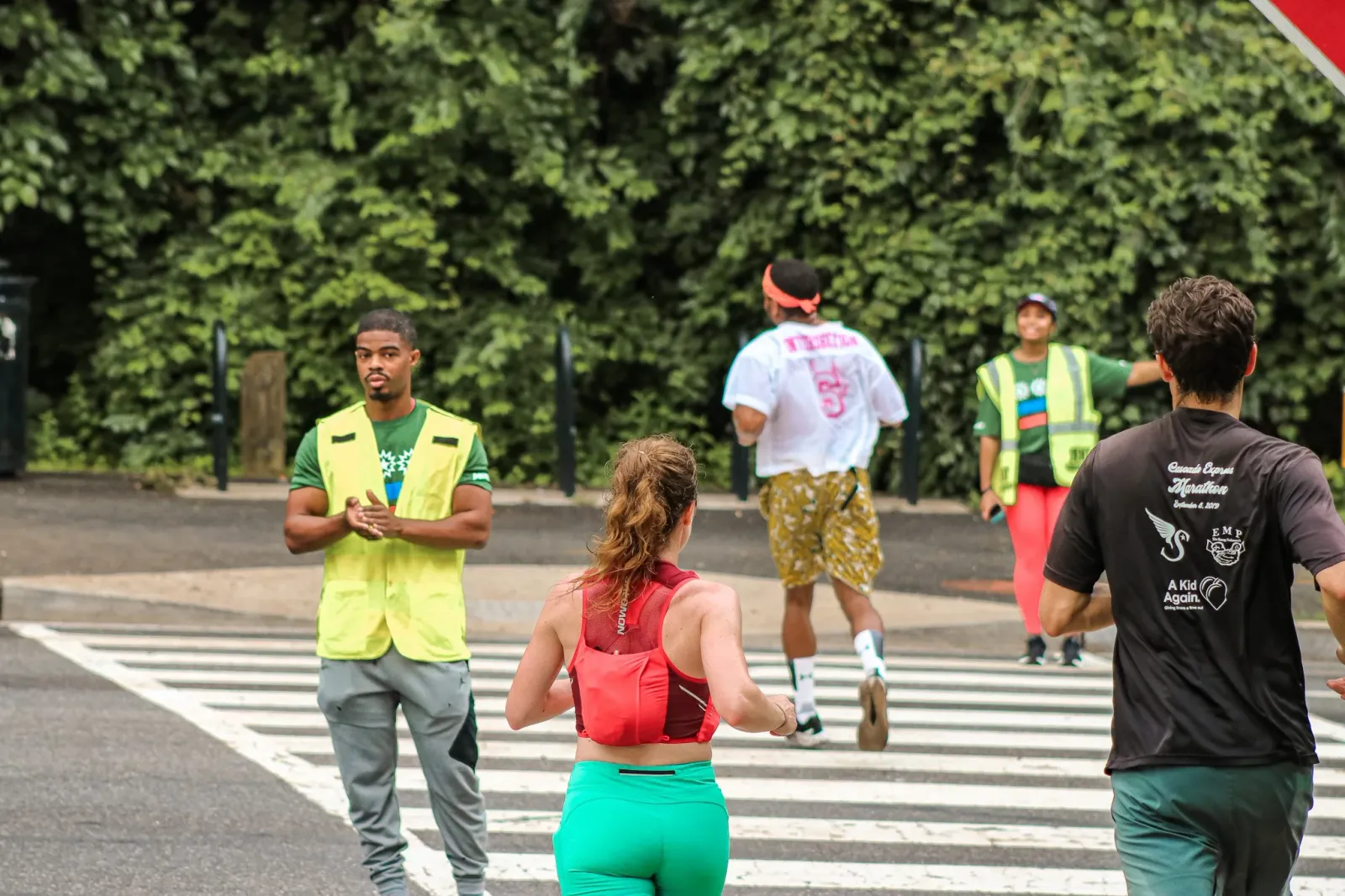 Runners and race volunteers on a crosswalk during a race.