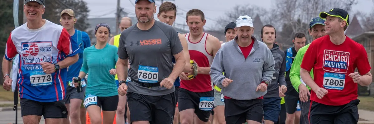 A group of runners participating in a race, with bib numbers visible on their shirts.