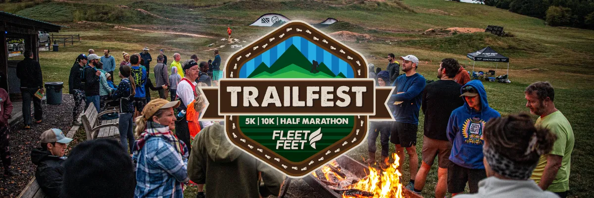 A group of people gathered around a campfire at the Trailfest 5K, 10K, Half Marathon event, with the race logo prominently displayed.