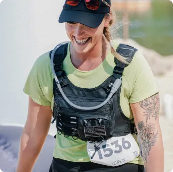 A smiling female runner wearing a hydration vest and a race bib numbered 1536.