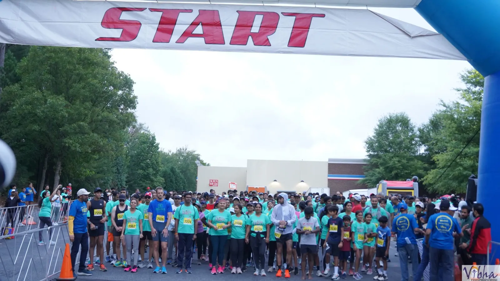 A large group of runners gathered at the start line under a banner that reads 'START'.