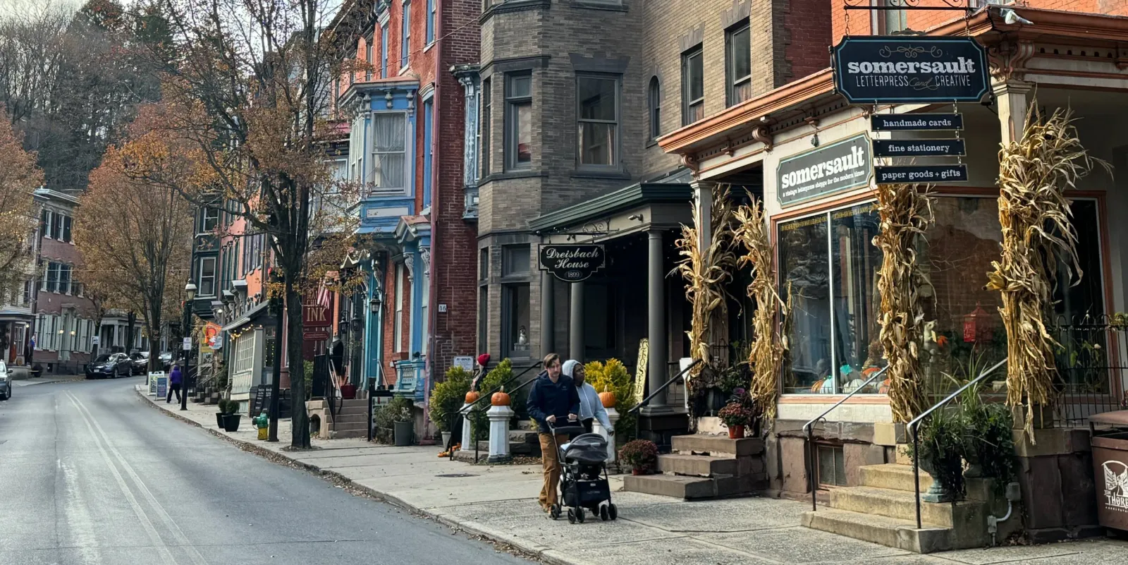 A street scene in Jim Thorpe, Pennsylvania, with colorful historic buildings and people walking on the sidewalk.