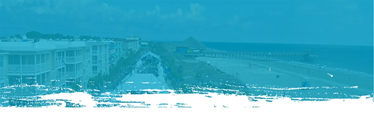 Scenic view of the Tybee Island beach with a pier and buildings along the coast.